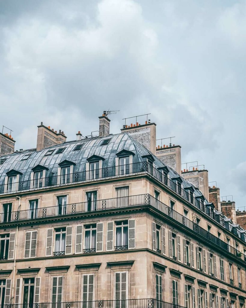 facade of aged Parisian residential house with high windows and balconies